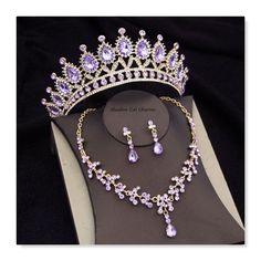 a purple tiara and necklace set on display in a jewelry box with black background