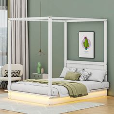 a white bed sitting on top of a hard wood floor next to a green wall