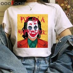 a woman wearing a white shirt with the image of a clown painted on it's chest