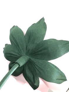 a green flower on top of a white surface