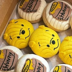 there are many cookies in the box with faces painted on them and one has been made to look like winnie the pooh