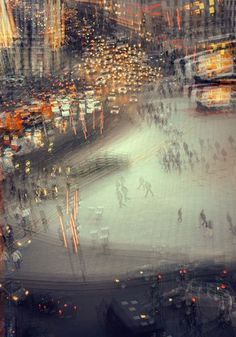 an aerial view of a city at night with lots of traffic and people walking on the street