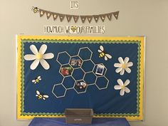 a bulletin board with pictures and flowers on it in front of a blue table cloth