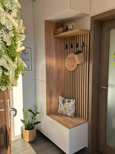 a wooden bench sitting inside of a room next to a potted plant