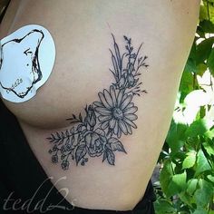 a woman's stomach with flowers on it and a sticker attached to the side