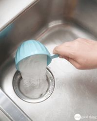 a person is washing their hands in the sink with a blue strainer on it