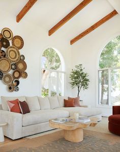 a living room filled with white furniture and lots of round mirrors hanging on the wall