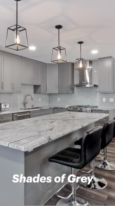 a kitchen with an island and bar stools next to the counter top in front of it