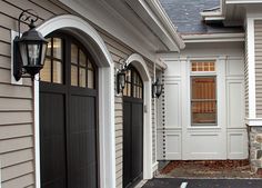 the front entrance to a house with two garage doors and an entry way leading into it