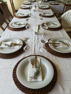 the table is set with white plates and silverware