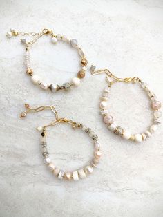 These elegant Australian Opal bracelets are a celebration of earthy elegance in beautiful creamy, white, ecru, beige, and touches of blue and pink. Some smaller heishi beads all the way up to bigger 10mm  to 12mm wheel beads of Australian Opal. Also a mix of neutral fresh water pearls, Gray Oyster Shell beads, Gray Opal, Iridescent Opal, Graphic Feldspar, and more. Mix in an array  of neutral quality Czech and seed beads. Beautiful texture and interest. Strung on Beadalon .015 7-strand Stainless Steel Bead Stringing wire-great strength and great flexibility. Unique shell and gray leather loop closure make this design extendable. One-of-a-kind. Item/s pictured is the item you will receive. Gold accents warm the neutral palette, creating a delicate contrast. At 7 inches and a 2 to 3-inch gol Earthy Elegance, Eye Bracelets, Fresh Water Pearls, Opal Bracelet, Chain Extenders, Water Pearls, Heishi Beads, Oyster Shell, Bead Stringing