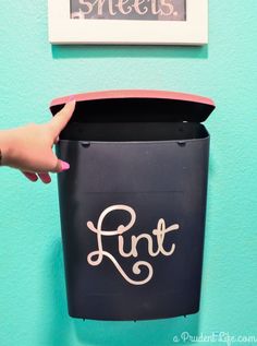 a person is holding a black box with the word fun written on it, in front of a blue wall