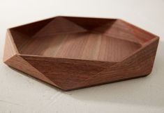 a wooden bowl sitting on top of a white table