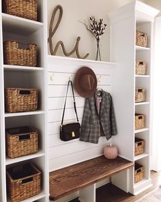 a coat rack with hats and purses on it next to a shelf filled with baskets