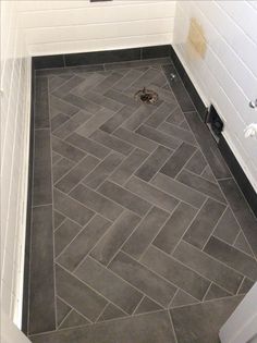 a bathroom with a gray tile floor and white walls