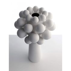 a white vase filled with balls on top of a table