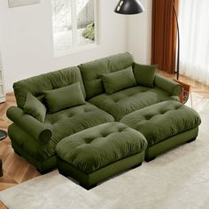 a large green couch sitting on top of a white rug in a living room next to a window