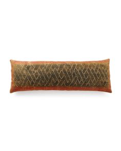 an orange and black decorative pillow on a white background