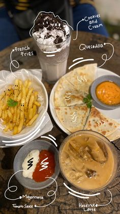 a table topped with plates of food next to cups of sauces and condiments