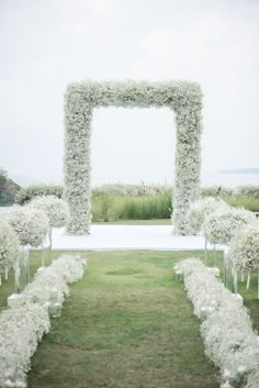 an outdoor ceremony with white flowers and greenery