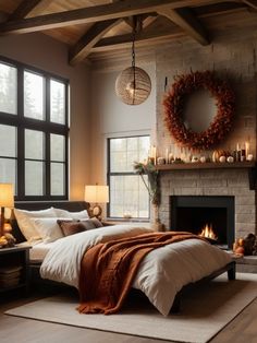 a bedroom with a large bed and fireplace in the corner, surrounded by windows that have candles on them