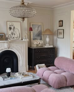 a living room filled with furniture and a fire place in front of a white fireplace