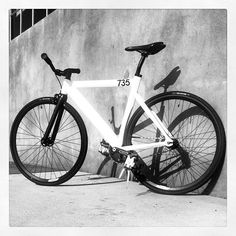 a white bicycle leaning against a wall