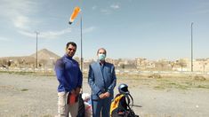 two men standing next to each other in the desert