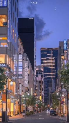 an empty city street at night with tall buildings