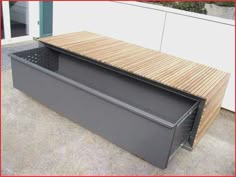 a bench made out of metal and wood with a built - in grill on top