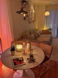 a living room filled with furniture and a lit candle on top of a round table