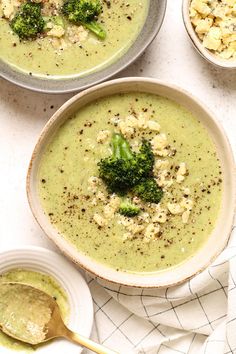 three bowls filled with broccoli soup on top of a table