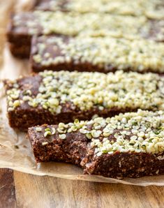 some brownies are sitting on a piece of parchment paper with sprinkles