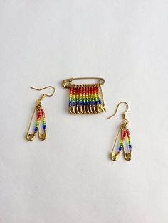 two pairs of earrings with multicolored beads and gold earwires on a white surface