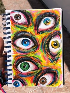 a hand holding a notebook with an eye pattern on it