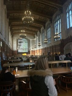 people are sitting at tables in an old building