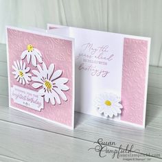 two cards with daisies on them, one is pink and the other is white