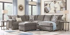 a living room with a sectional couch and ottoman