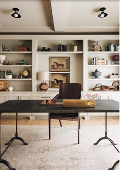 an office with shelves, desk and chairs