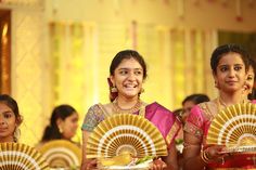 two women holding fan shaped plates in front of them