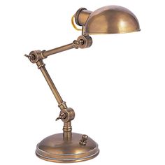 an antique brass desk lamp on a white background