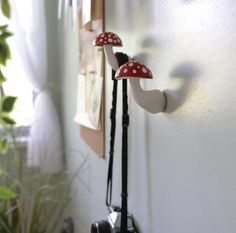 two mushrooms are hanging on the wall next to a camera and a potted plant