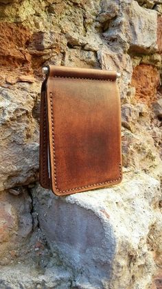 a brown leather wallet sitting on top of a rock