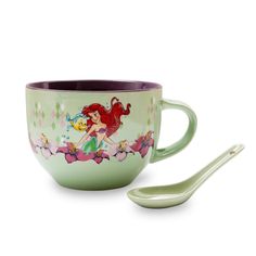 the little mermaid coffee cup and spoon is next to it