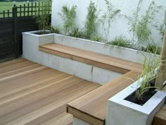 a wooden deck with planters and benches on it