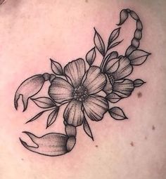 a black and white flower tattoo on the back of a woman's shoulder