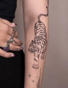 a woman's arm with a tiger tattoo on it