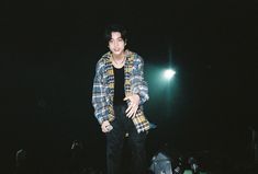 a man standing on top of a stage in the dark