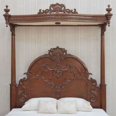 an ornate wooden bed frame with white pillows