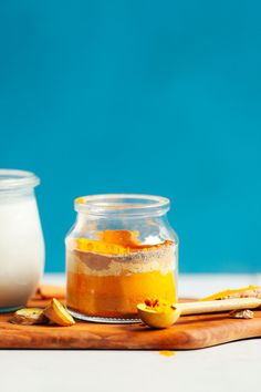 two jars filled with food sitting on top of a wooden table next to each other